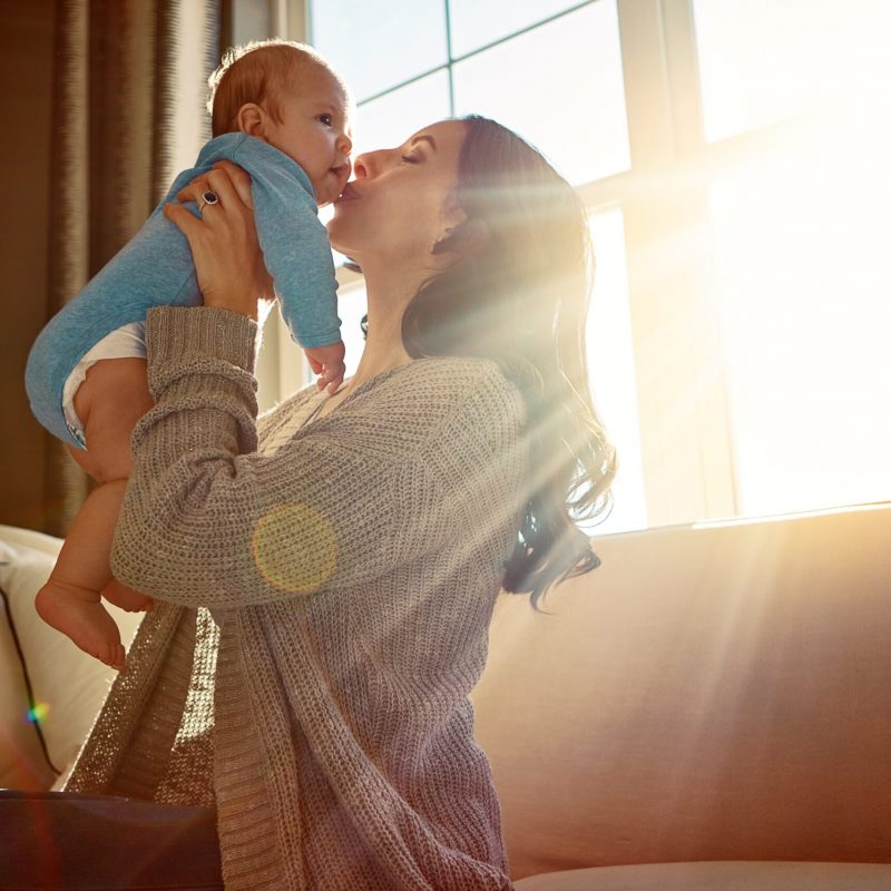 Mother,,Baby,And,Kiss,On,Cheek,In,Living,Room,On